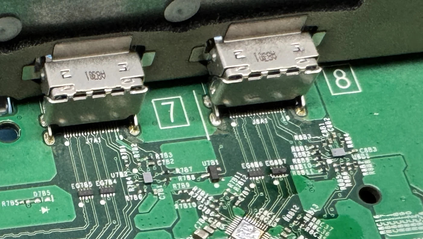 Dva HDMI konektory a pájené kontakty na základní desce konzole Xbox v naší dílně